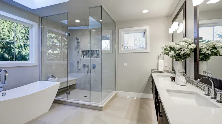 Modern bathroom remodel with clear glass shower walls and a frameless door for an open-concept design.